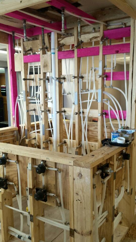 Multiple plumbing fixture connections installed in a commercial wall