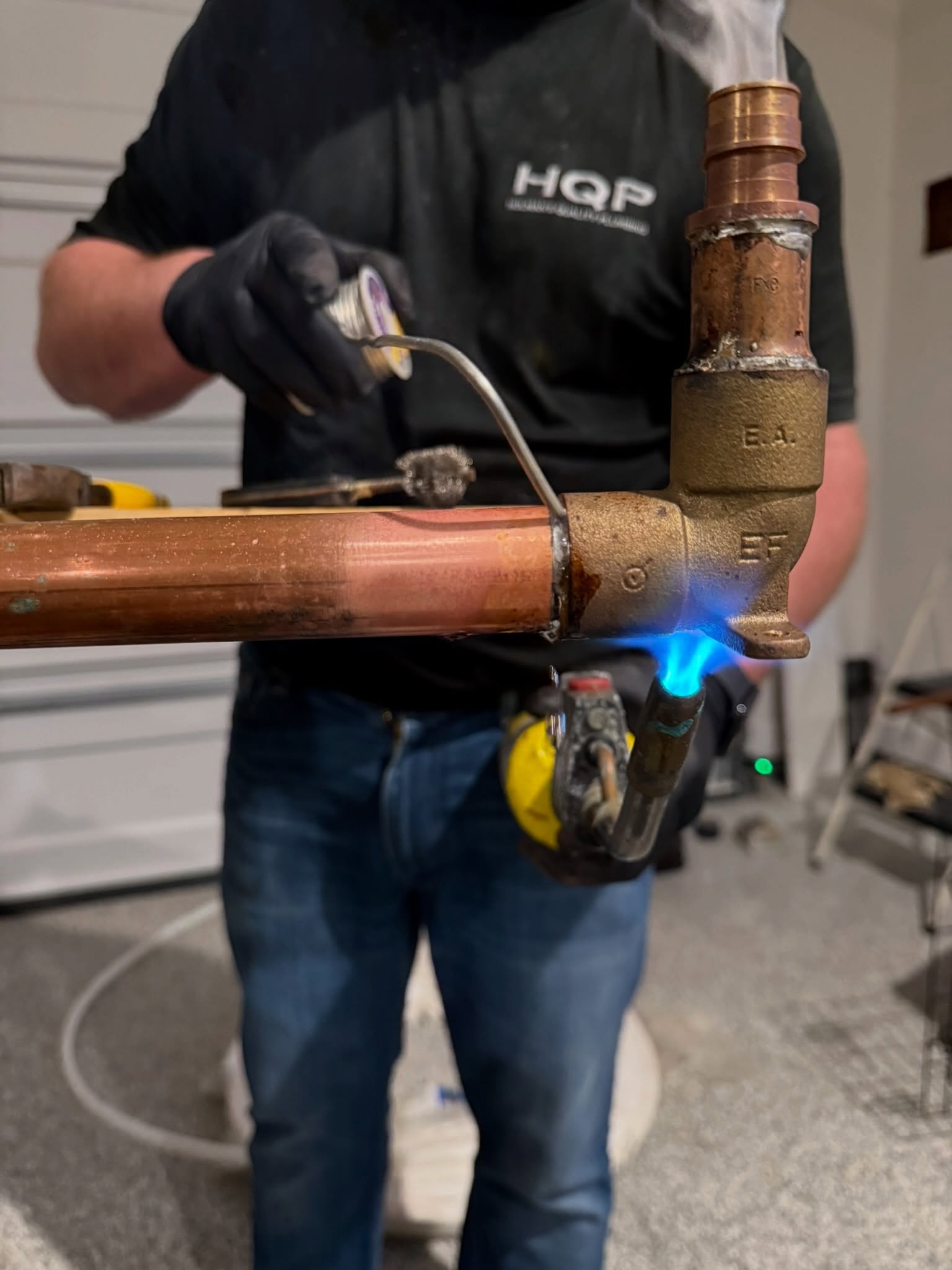 Holman's Quality Plumbing technician repairing a copper water pipe